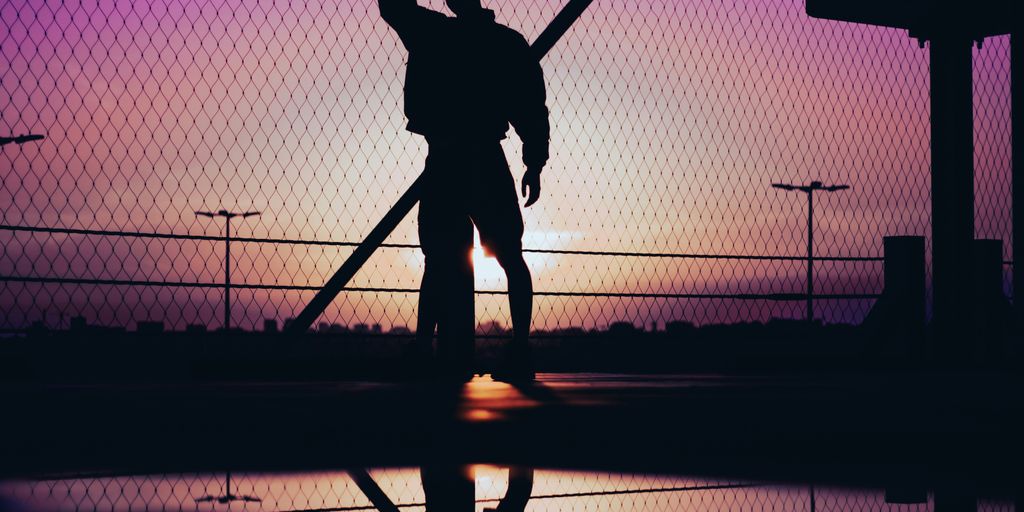 a silhouette of a man holding a baseball bat
